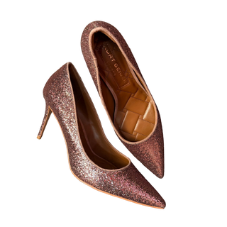 Pair of glittery high-heeled shoes on a wooden surface