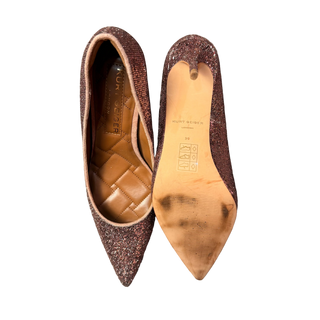 Pair of glittery brown shoes on a wooden surface