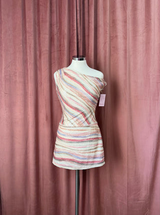 Mannequin wearing a colorful striped dress against a pink curtain background