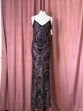 Elegant evening gown on a mannequin against a pink curtain background