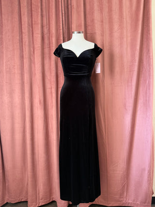 Black evening gown on a mannequin against a pink curtain background