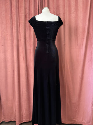 Black evening gown on a mannequin against a pink curtain background